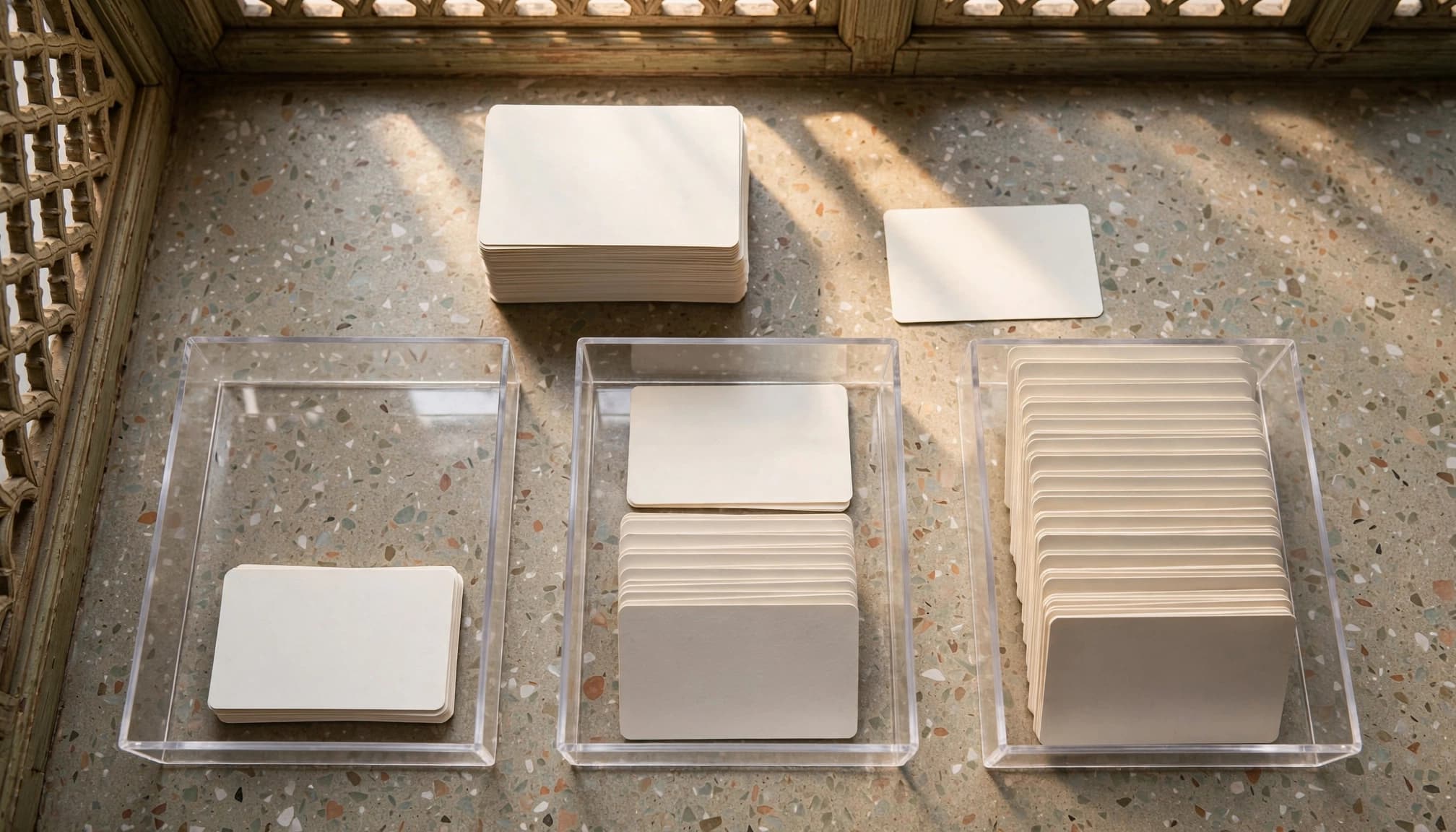 Blank inquiry cards are sorted into three trays in a sunlit office.