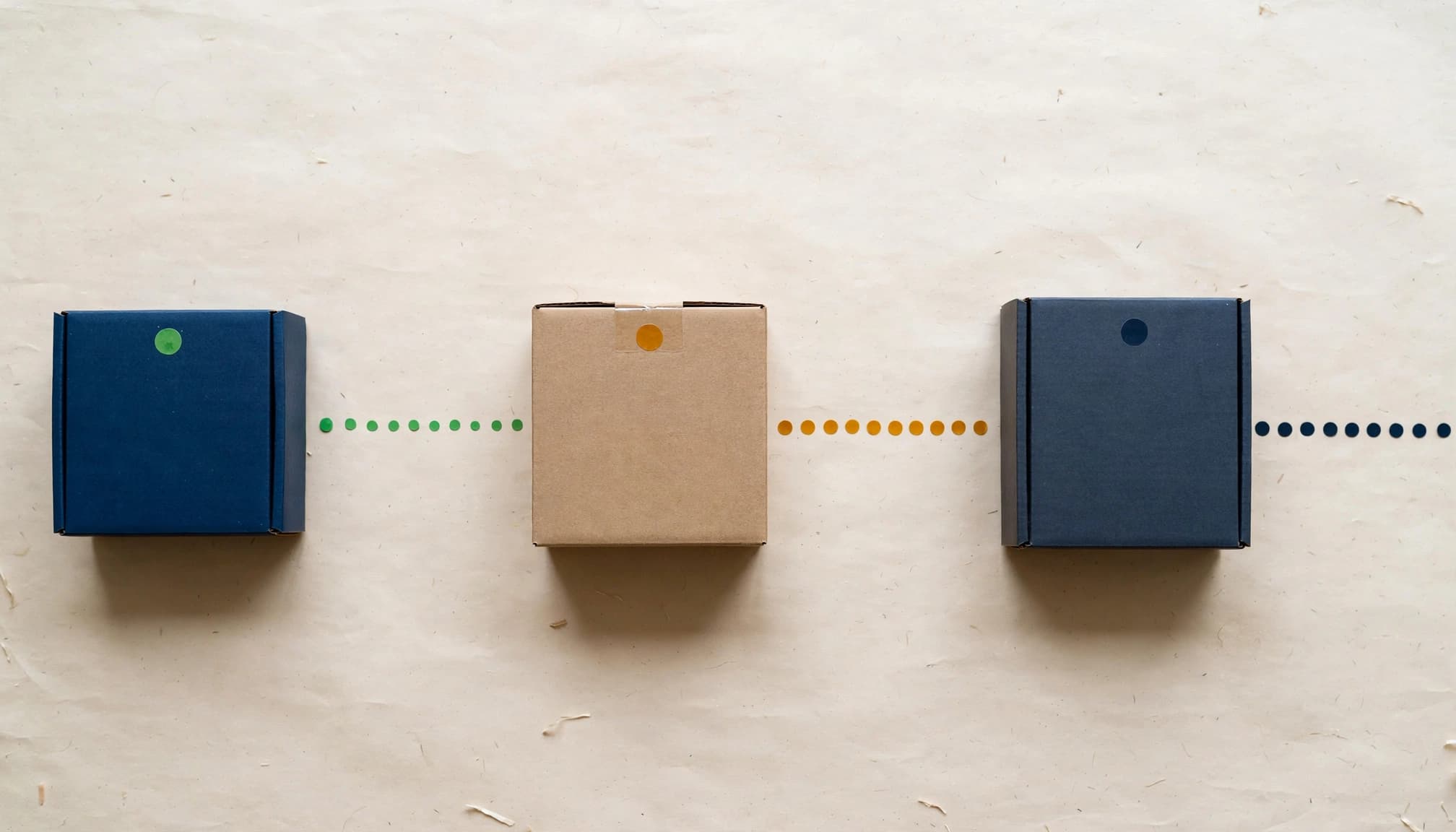Three separated product boxes have colored status dots on a clean table.
